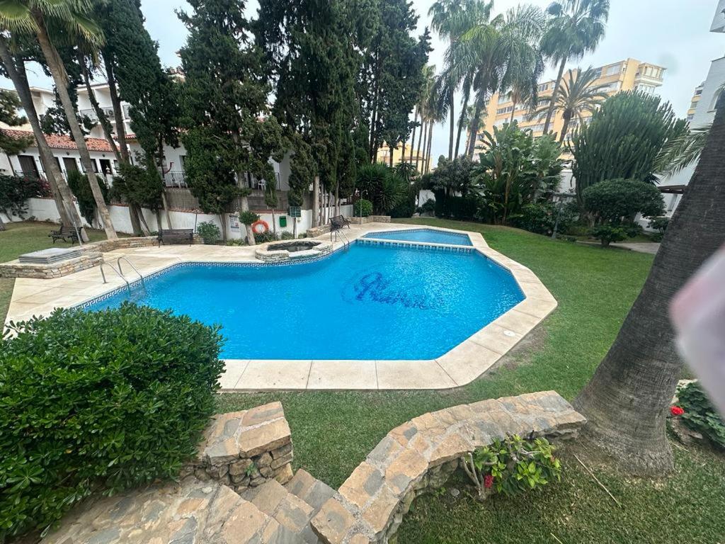 una gran piscina azul en un patio en Ola Blanca Carihuela Apartamento, en Torremolinos