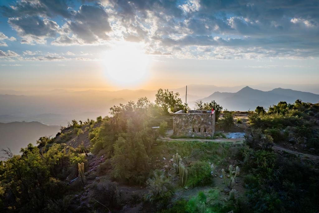 聖地亞哥的住宿－Lodge Pochoco Refugio de Montaña，山上日落的太阳图像