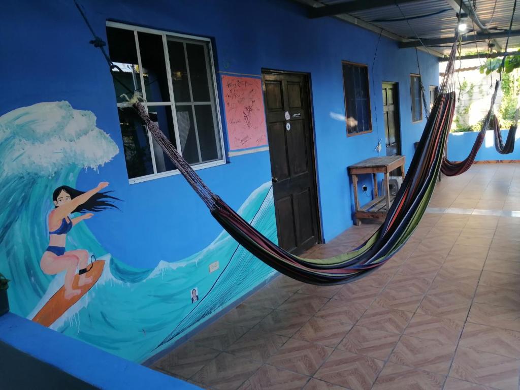 Tamanique的住宿－Hostal Niña Oly，一间设有美人鱼画和吊床的客房