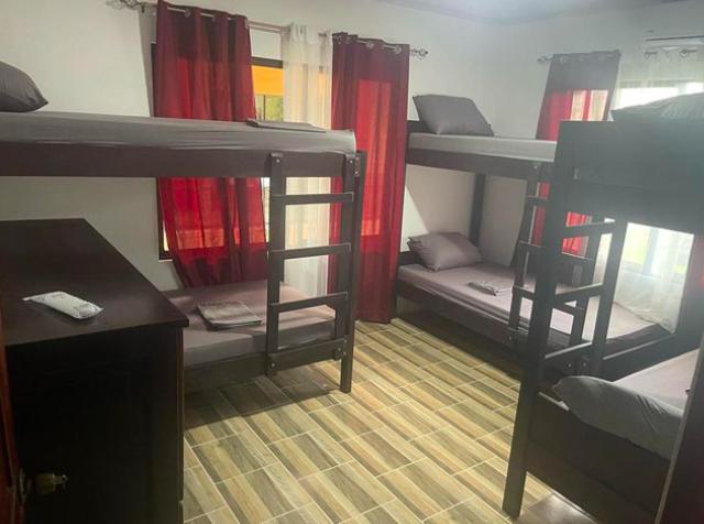 Schlafsaal mit Etagenbetten, einem Schreibtisch und einem Tisch in der Unterkunft Sky Hostel in Fortuna
