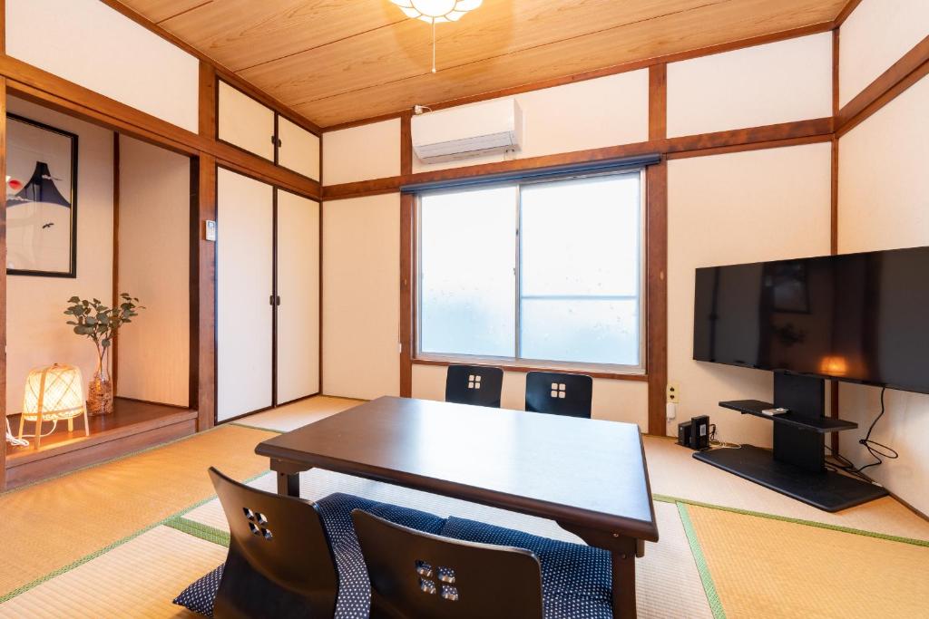 a living room with a table and a tv at GuestHouse　YOU&I平和島 in Tokyo