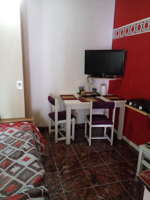 a room with a desk with a computer and a bed at Apart Alcázar in Trelew