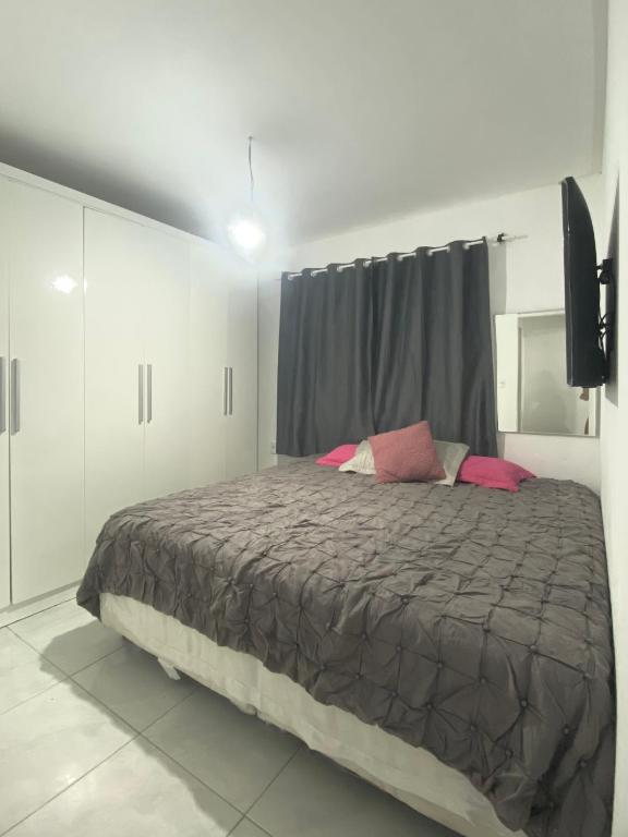 1 dormitorio con 1 cama grande con almohadas rosas en Casa em Balneário Camboriú, en Camboriú