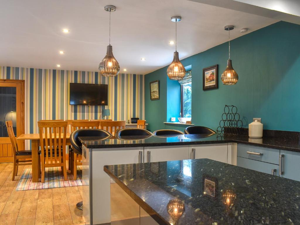 a kitchen and living room with blue walls and a table at Larpool Mews in Whitby