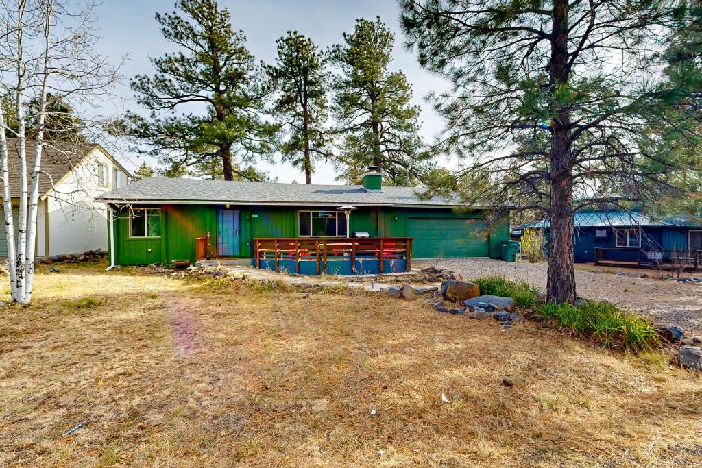 a green house with a picnic table in front of it at Caribou Cabin in Munds Park