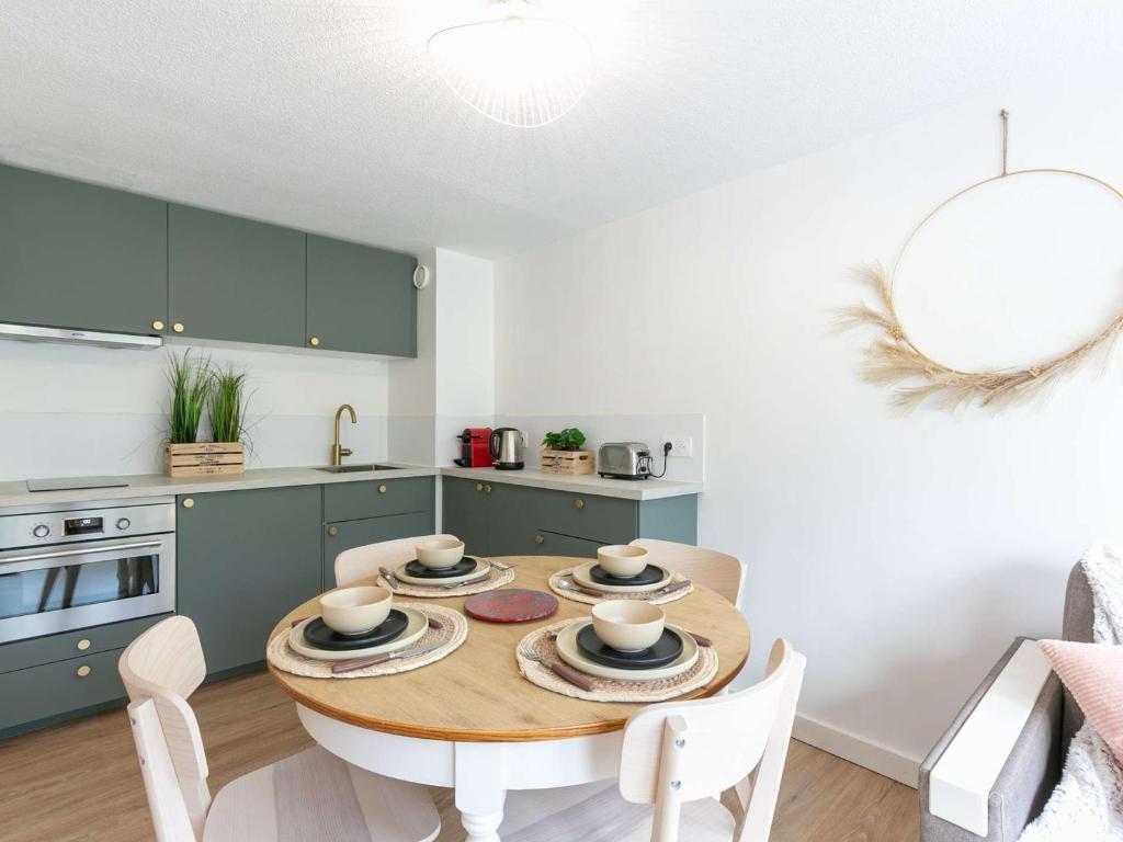 une cuisine avec une table en bois et des plaques de cuisson. dans l'établissement Duplex T2 rénové pour 4 personnes à Vielle-Aure avec parking privé et navette gratuite - FR-1-296-487, à Vielle-Aure
