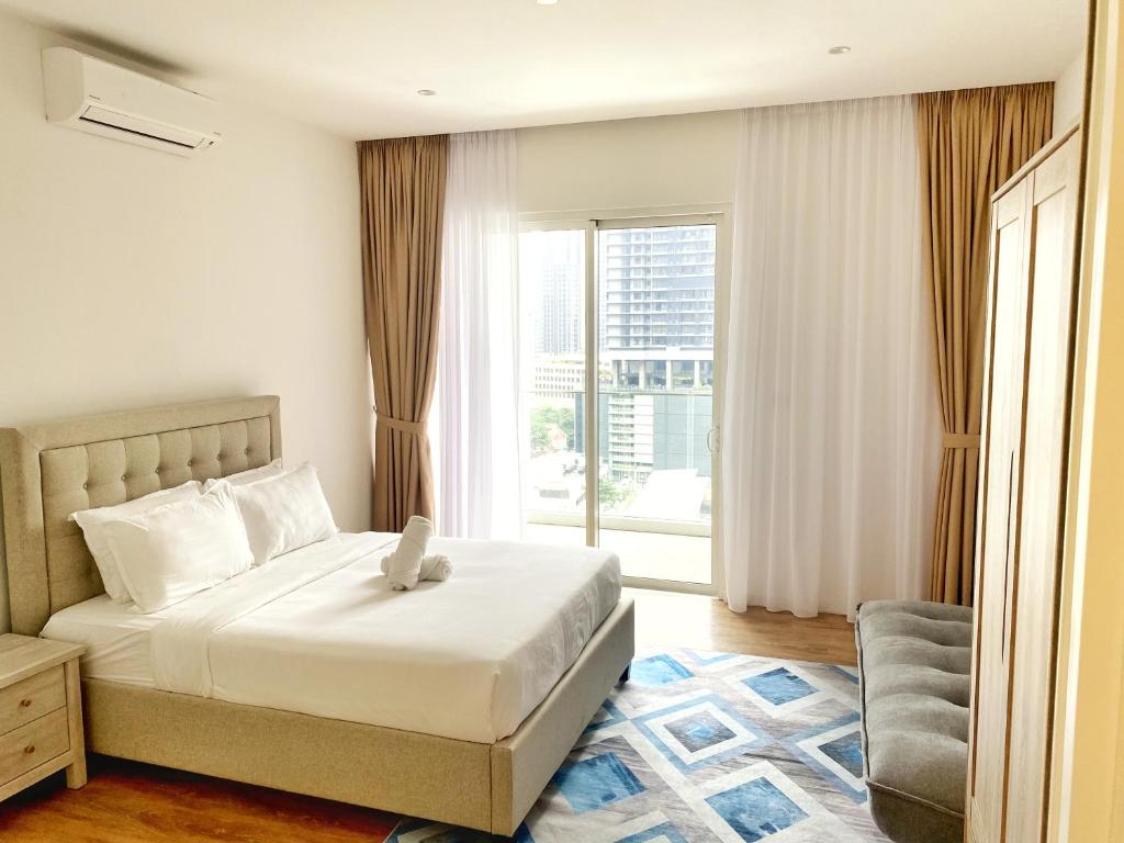 a bedroom with a bed and a large window at Lila Suites Quill Residences Klcc in Kuala Lumpur