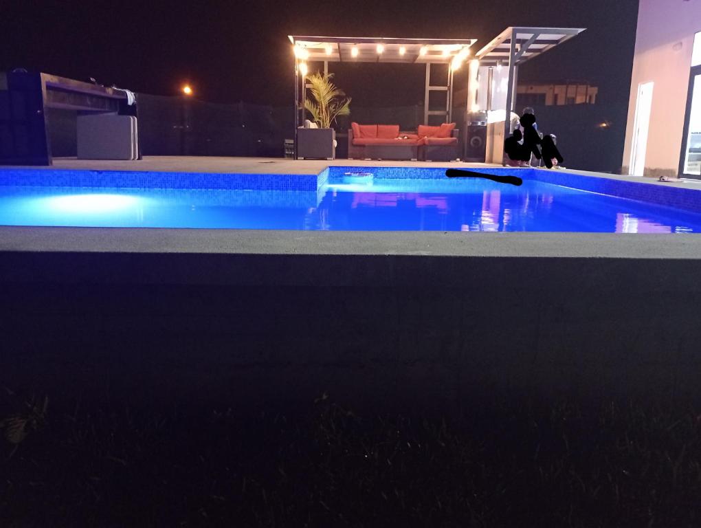 una piscina iluminada por la noche en Alquilo Casa playa, en San Antonio