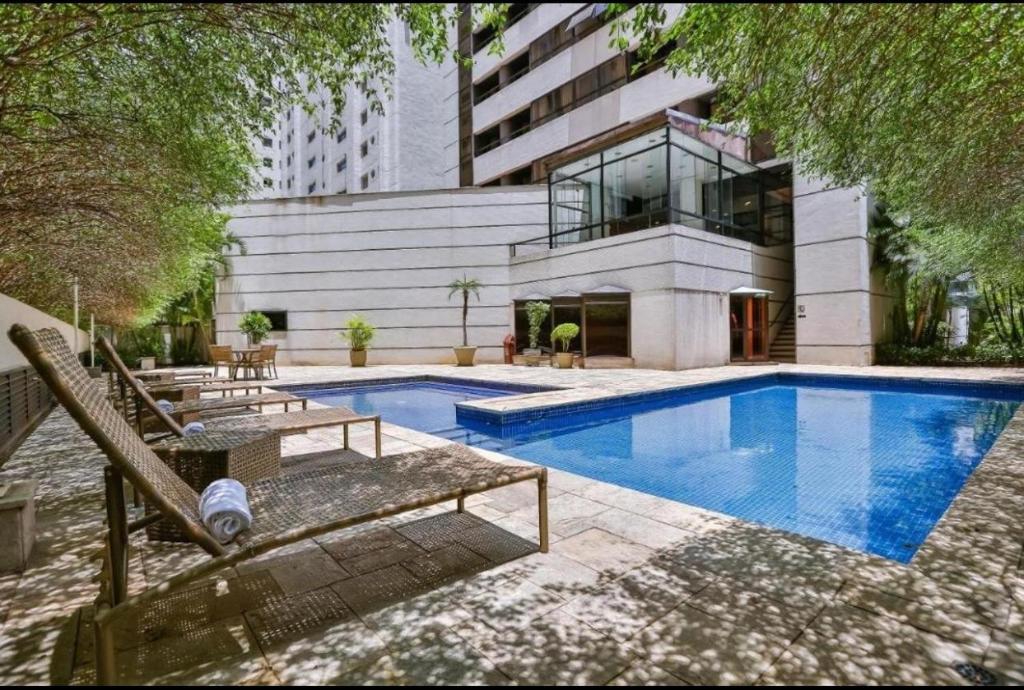 a swimming pool in front of a building at Studio Living Quality Jardins in Sao Paulo
