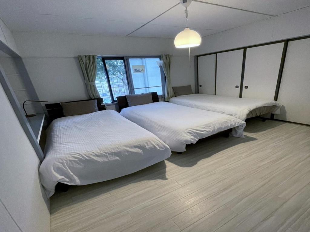 two beds in a room with white sheets at Otaru - House - Vacation STAY 15278 in Otaru