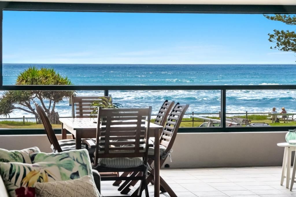 a balcony with chairs and a table and a view of the ocean at Sea Spray - Lennox Head in Lennox Head