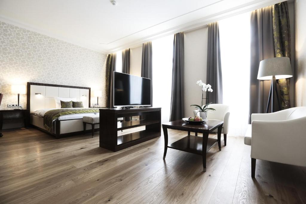 ein Hotelzimmer mit einem Bett, einem TV und einem Tisch in der Unterkunft Kleiner Rosengarten in Mannheim