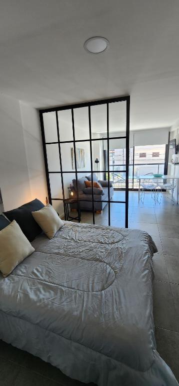 1 dormitorio con 1 cama y ventana grande en Monoambiente premium Paso en Mar del Plata