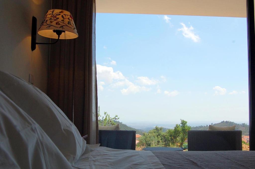 una camera con un letto e una grande finestra di Vinha do Gaio a Monchique
