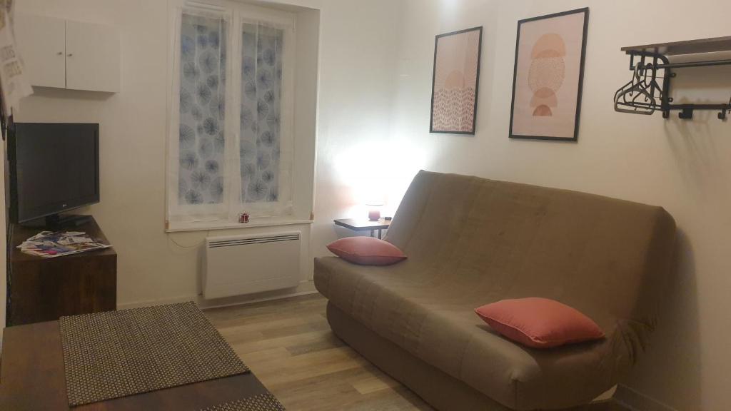uma sala de estar com um sofá e uma televisão em Studio meublé et équipé em Ingré