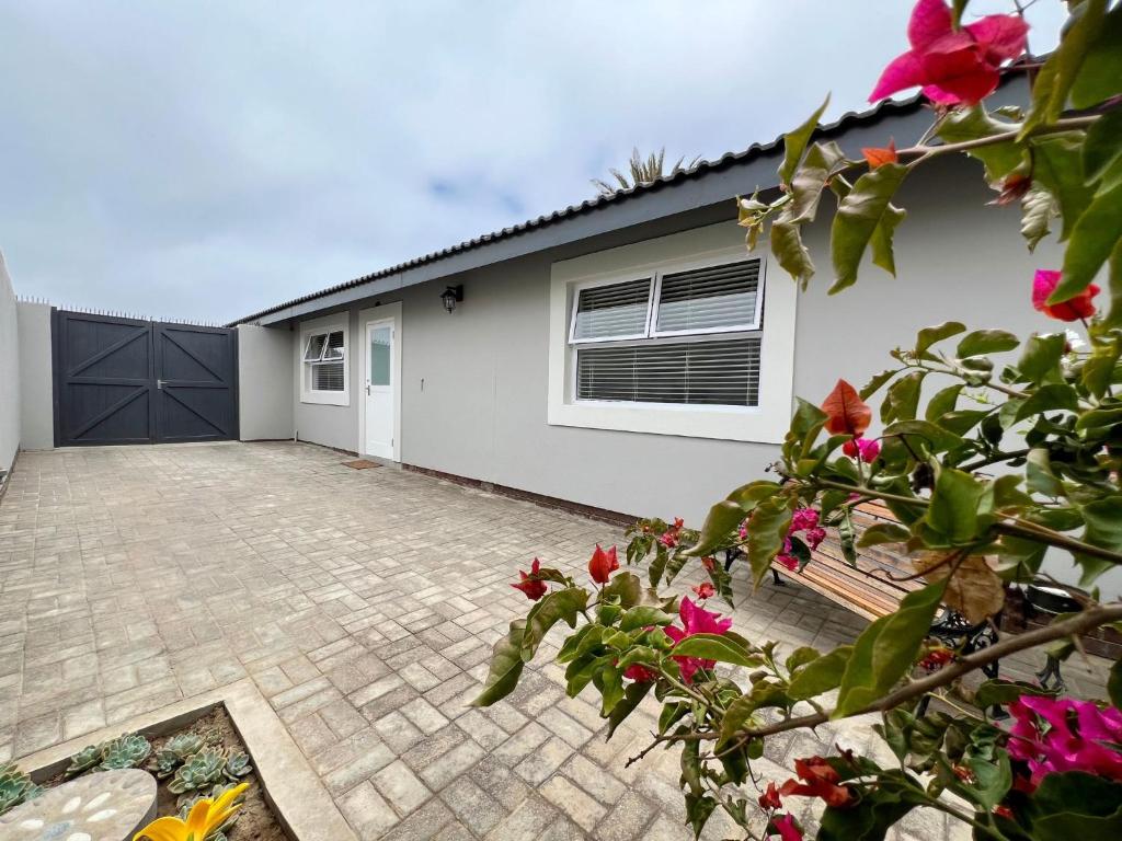 a house with a driveway and flowers in front of it at AuobCorner in Walvis Bay