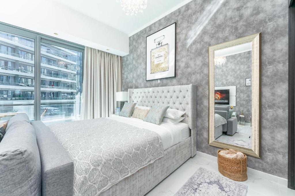 a bedroom with a large bed and a mirror at LUX Holiday Home Dubai Marina JBR - Silverene Tower Studios in Dubai