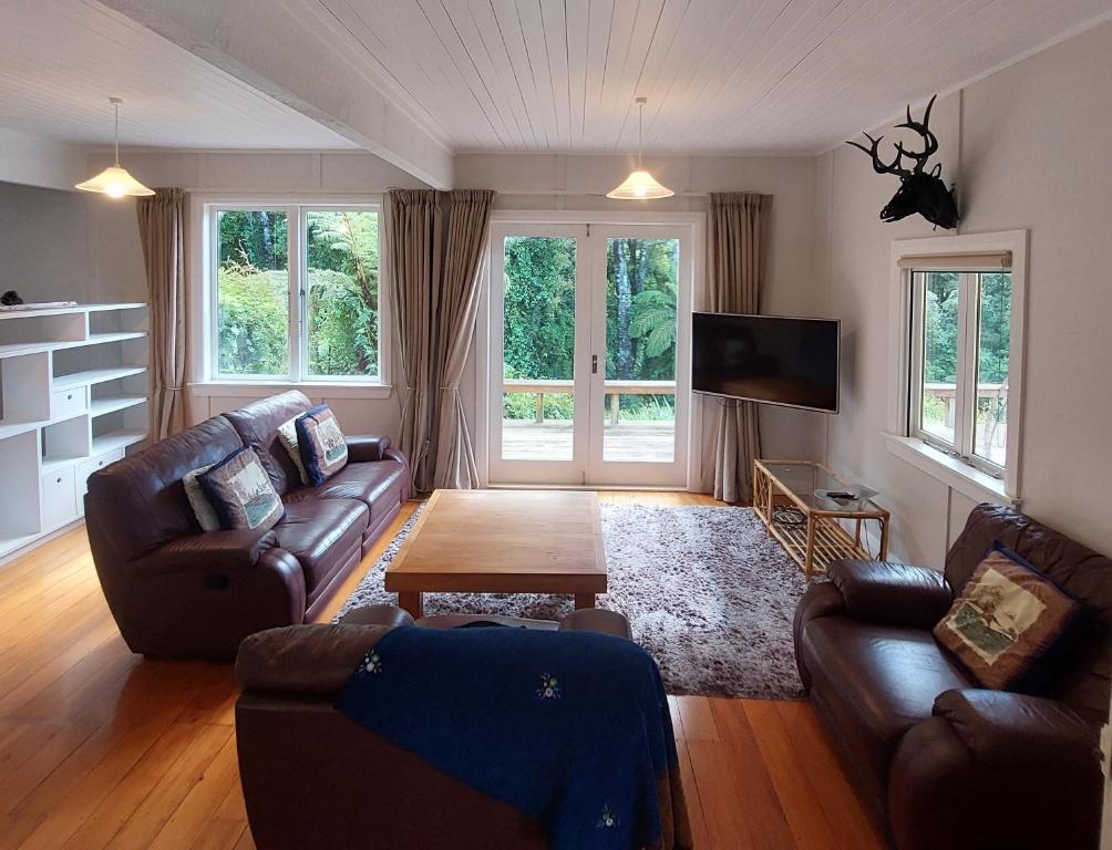 een woonkamer met twee banken en een tv bij Morere cottage in Morere