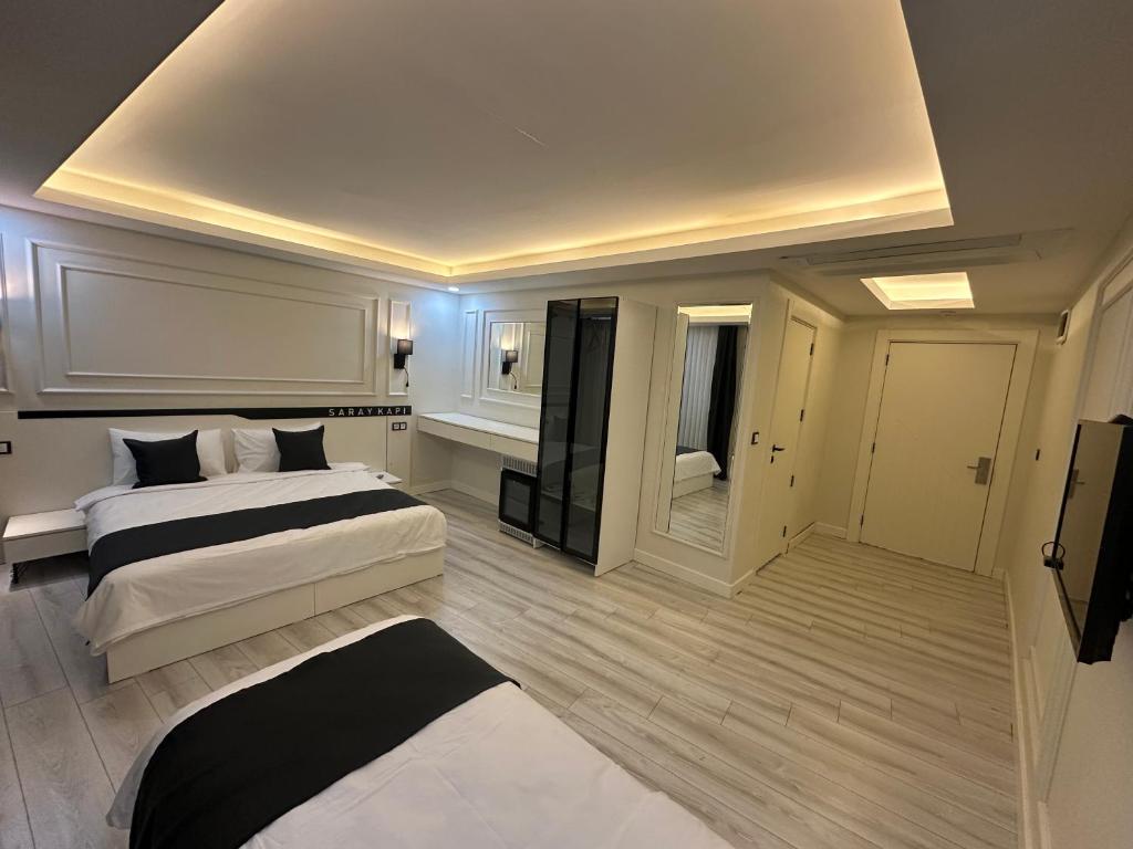 duża sypialnia z 2 łóżkami i telewizorem w obiekcie Mitra otel w mieście Diyarbakır