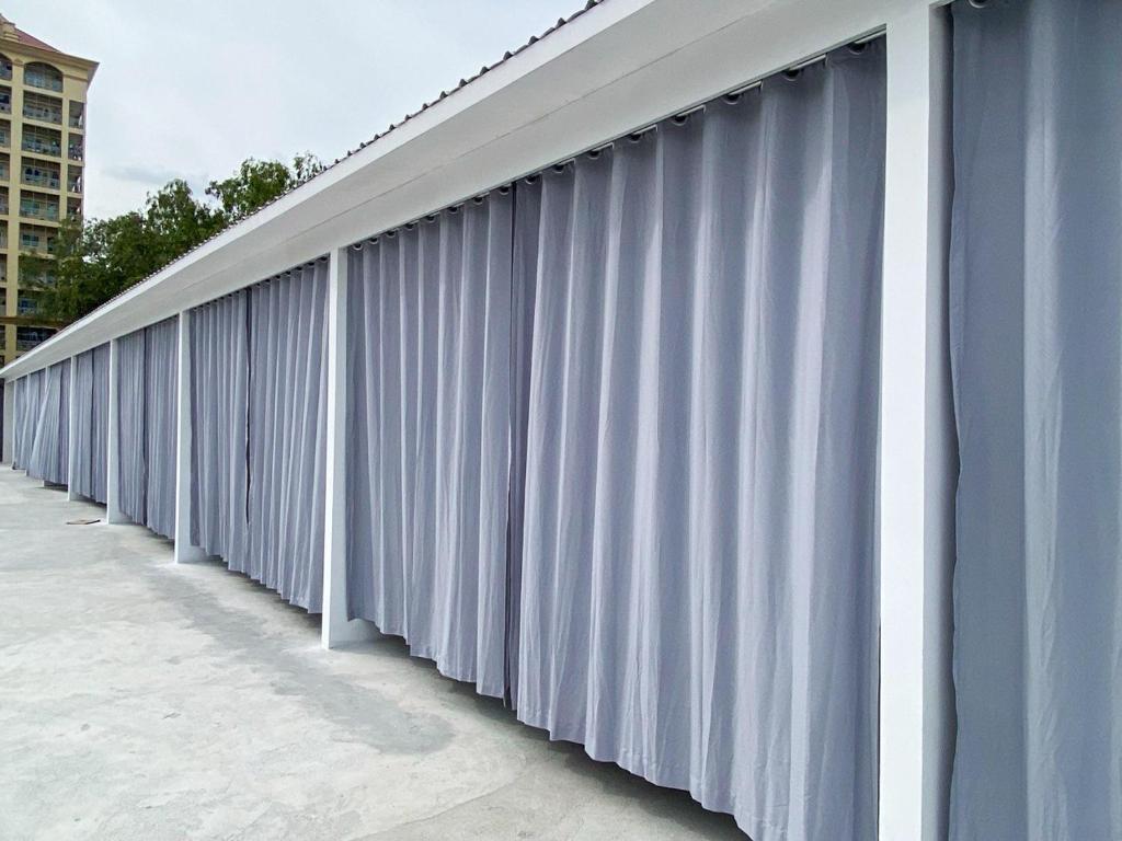 a long line of white curtains on a building at K-Road in Phnom Penh