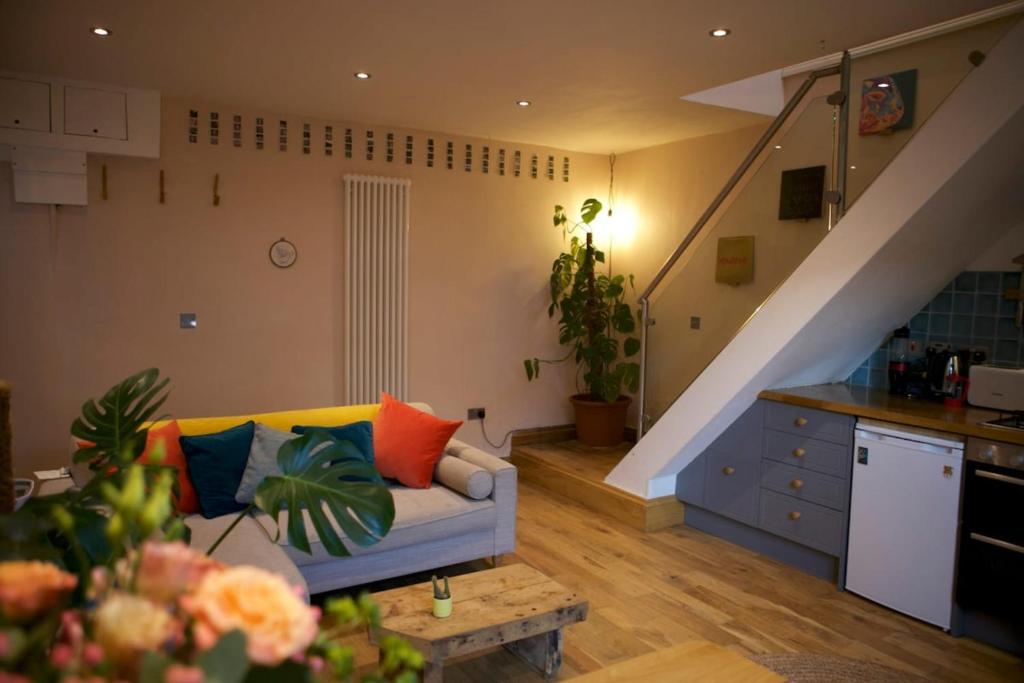 ein Wohnzimmer mit einem Sofa und einer Treppe in der Unterkunft Inviting & Secluded 1BD House w Patio - Peckham! in London