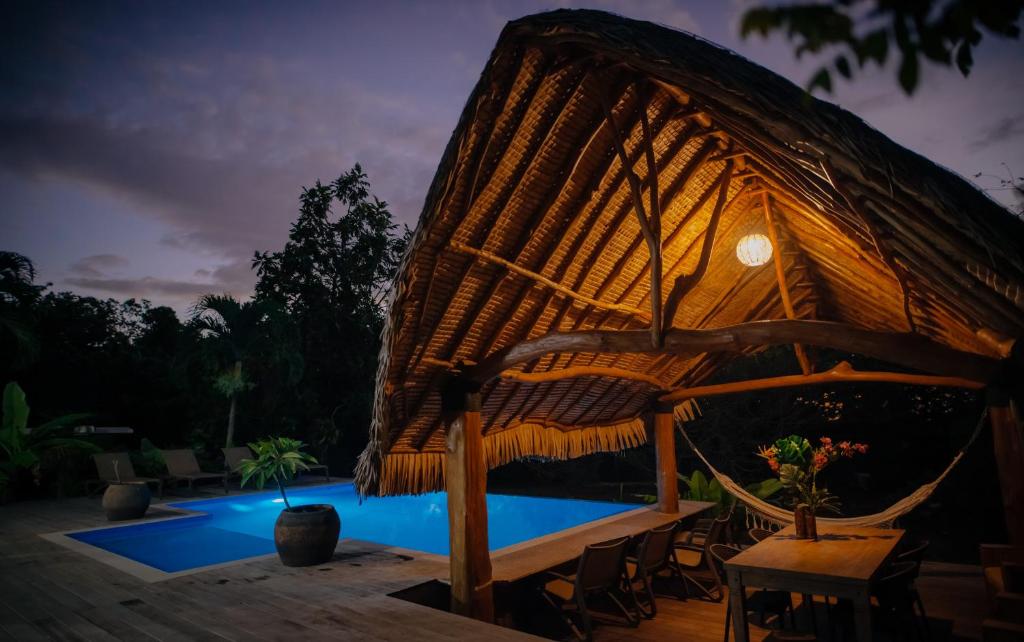 una gran silla de mimbre junto a una piscina en Tokoau Uta, en Moorea