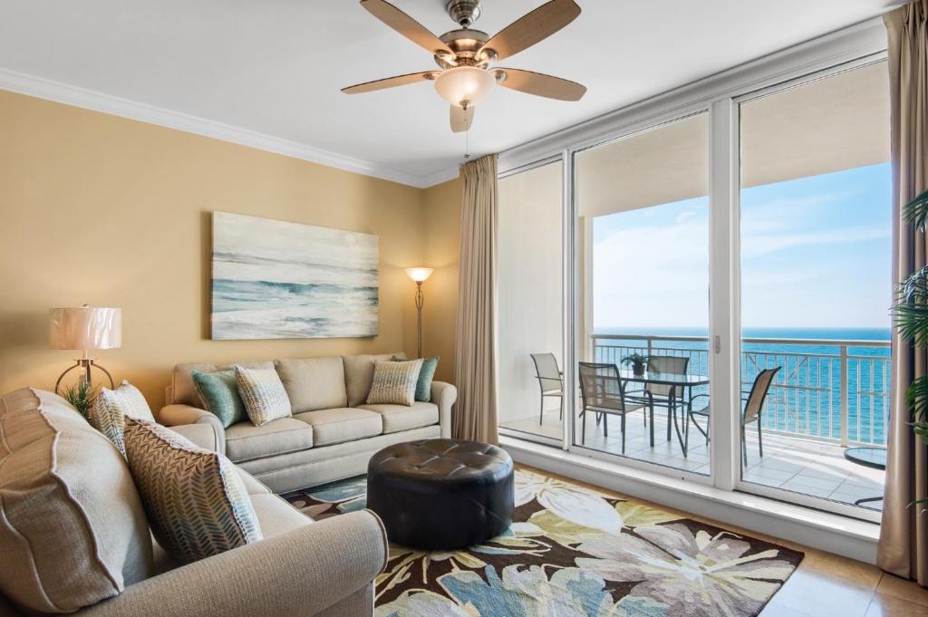 Beach Front Luxury, Amazing Views,150 - 5 Stars, 19th Floor- Indigo Condo في بينساكولا: غرفة معيشة مع أريكة وإطلالة على المحيط
