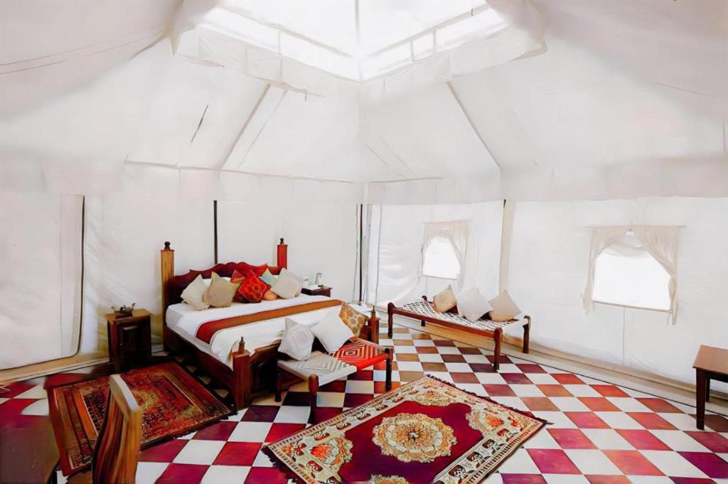 a bedroom with a bed and a checkered floor at Desert Signature Resorts in Sām