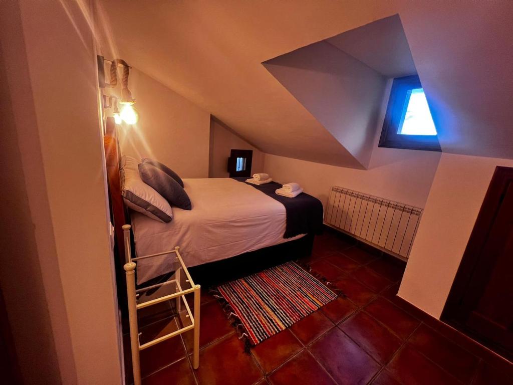 Habitación pequeña con cama y ventana en Rascacielos San Martín, en Cuenca