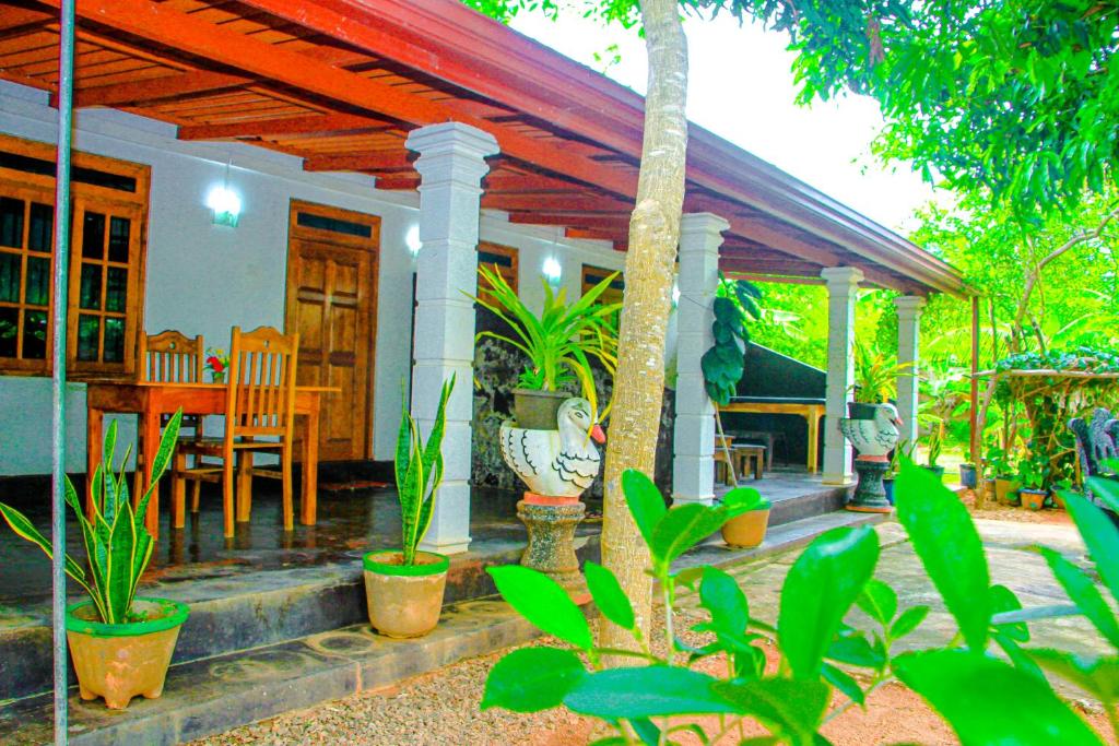 une maison avec une terrasse couverte dotée d'une table et de chaises dans l'établissement Mahee Villa & Ayurvedic Spa, à Dambulla