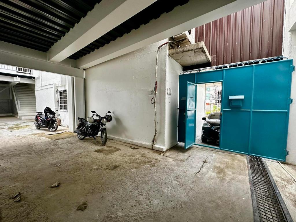 dos motocicletas estacionadas en un garaje con una puerta azul en FLATFORM RENTALS (PAWN'S ROOM) en Cebú