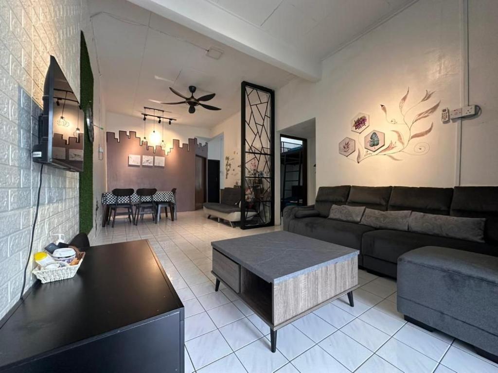 uma sala de estar com um sofá e uma mesa em STAY N REST SWEET HOME Duyung 207 em Seremban