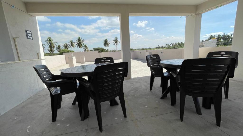 a patio with tables and chairs on a balcony at Mamatha Guest inn in Hampi
