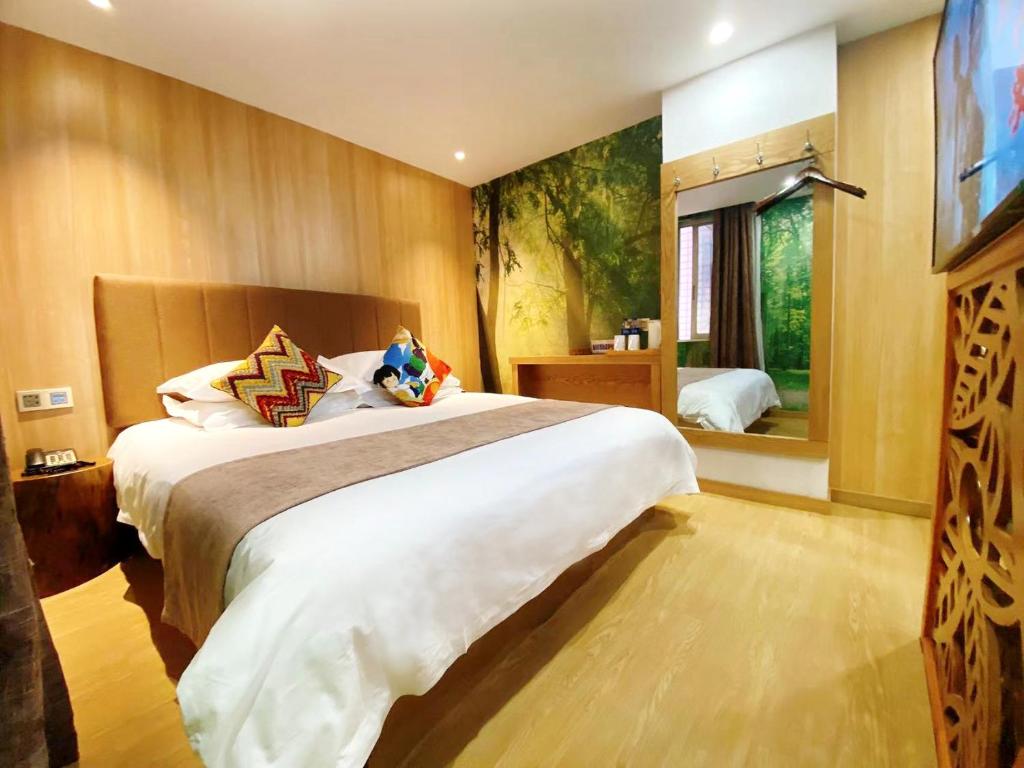 una camera d'albergo con un grande letto e una TV di Fresh Hours Hotel - West Lake Qingchun a Hangzhou