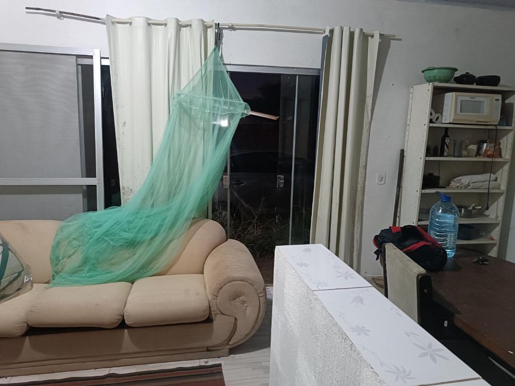 uma sala de estar com um sofá com uma rede em Casinha em Chapada Florada em Chapada dos Guimarães
