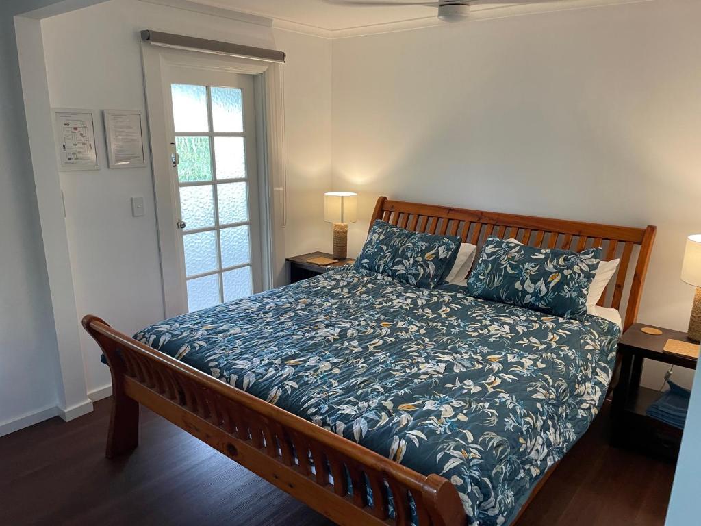 een slaapkamer met een bed met een blauw dekbed bij Bellingen Treehouse in Bellingen