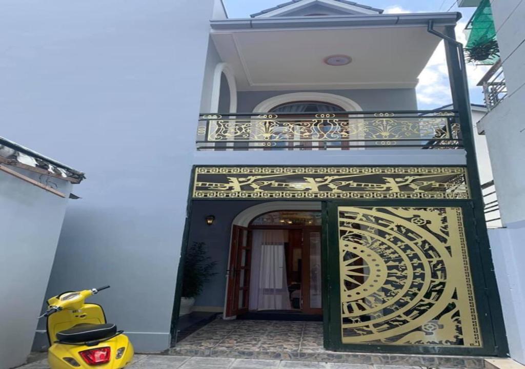 una moto amarilla estacionada frente a un edificio en NHỚ House III, en Da Lat