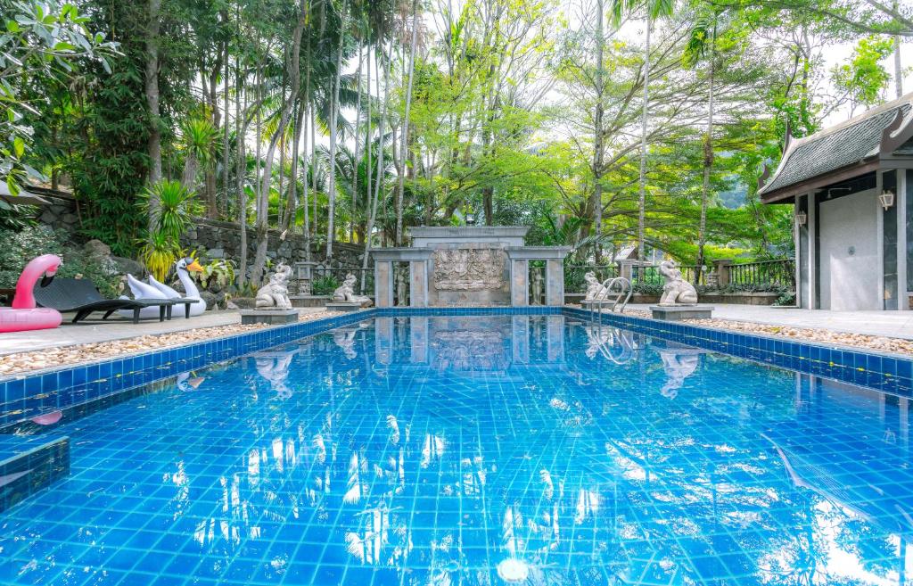 a swimming pool with a pink flamingo in a yard at Classic Thai style Cozy Villa pool garden in Patong Beach