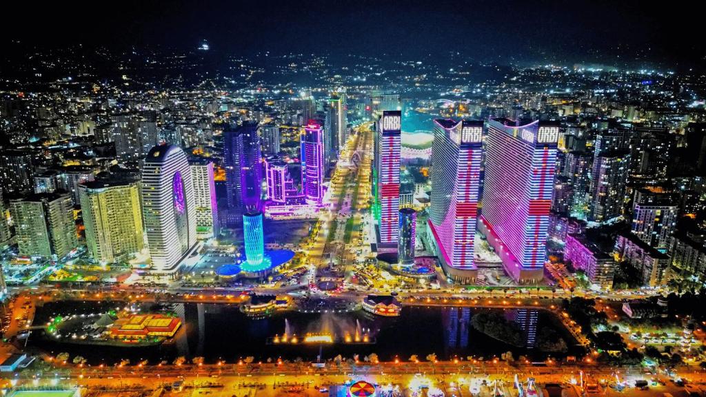 a city lit up at night with buildings at ORBI CITY - Central Apartment in Batumi