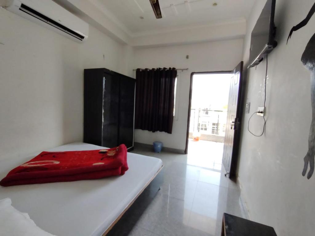 a room with a red object sitting on a bed at Hotel Aman in Rishīkesh