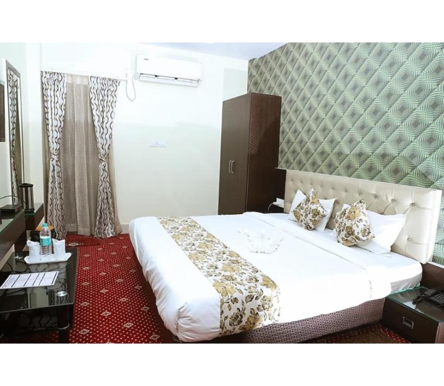a bedroom with a large white bed in a room at Hotel Janvi International Inn, Muzaffarpur in Muzaffarpur