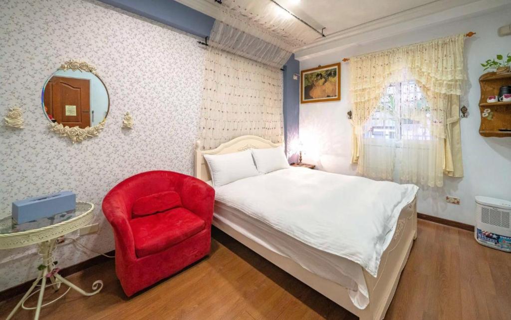 a bedroom with a bed and a red chair at Dot Minsu in Wujie