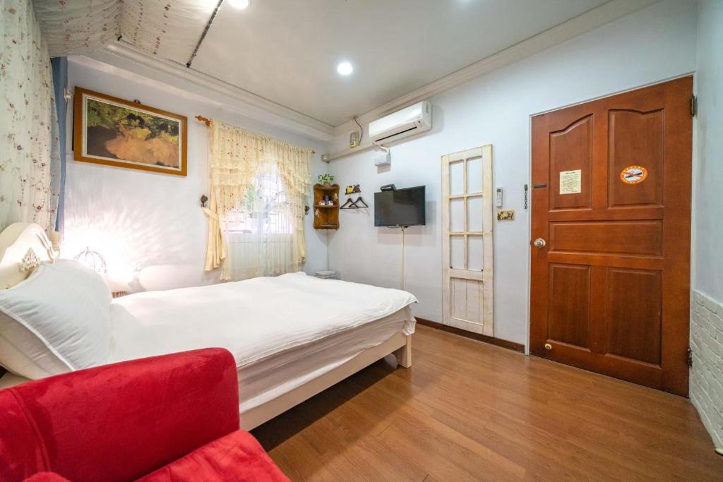 a bedroom with a white bed and a red couch at Dot Minsu in Wujie