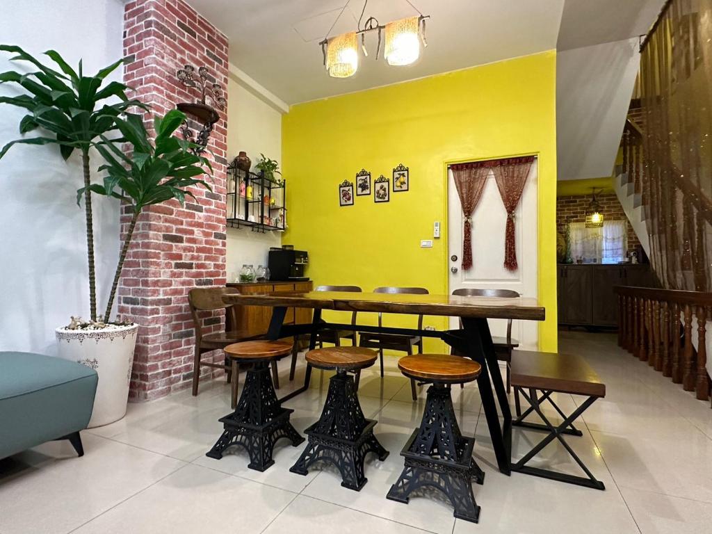 a restaurant with a table and chairs and a yellow wall at Dot Minsu in Wujie