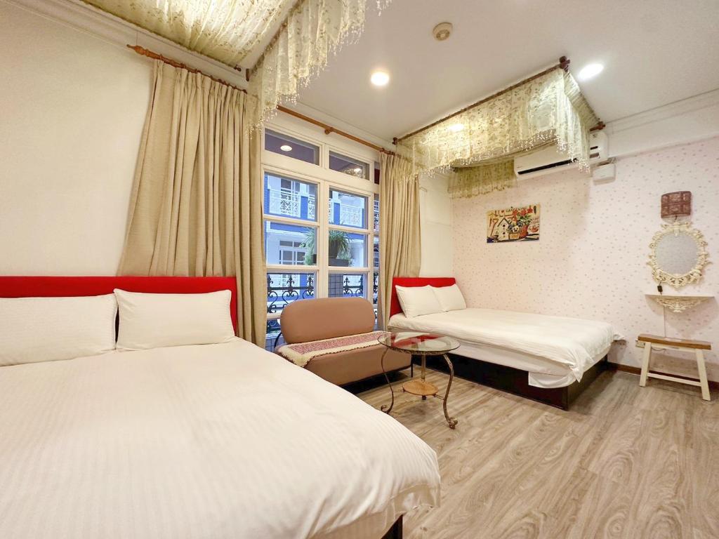 a bedroom with two beds and a chair and a window at Dot Minsu in Wujie