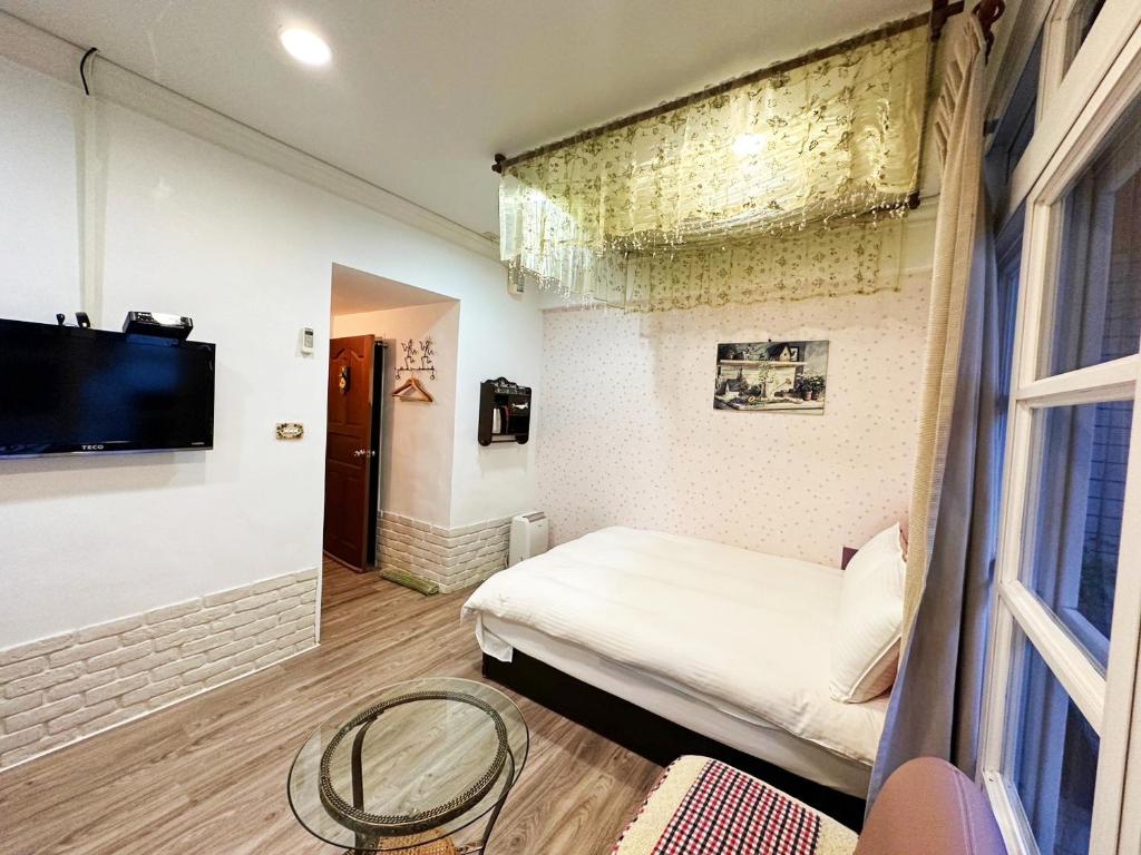a small room with a bed and a tv at Dot Minsu in Wujie