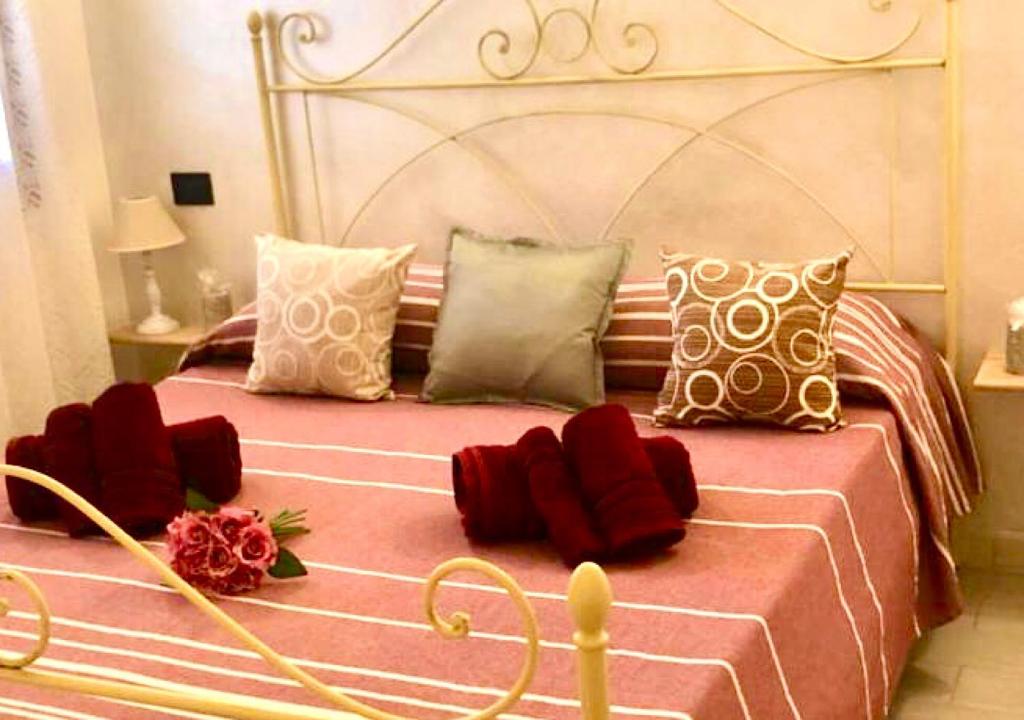 オルビアにあるONE BEDROOM WITH KITCHENETTE La Maison de Gioelのベッドルーム1室(大型ベッド1台、赤い枕付)