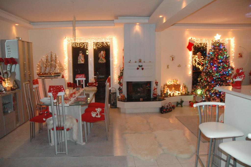 een woonkamer met een kerstboom en een open haard bij ellie in Patra