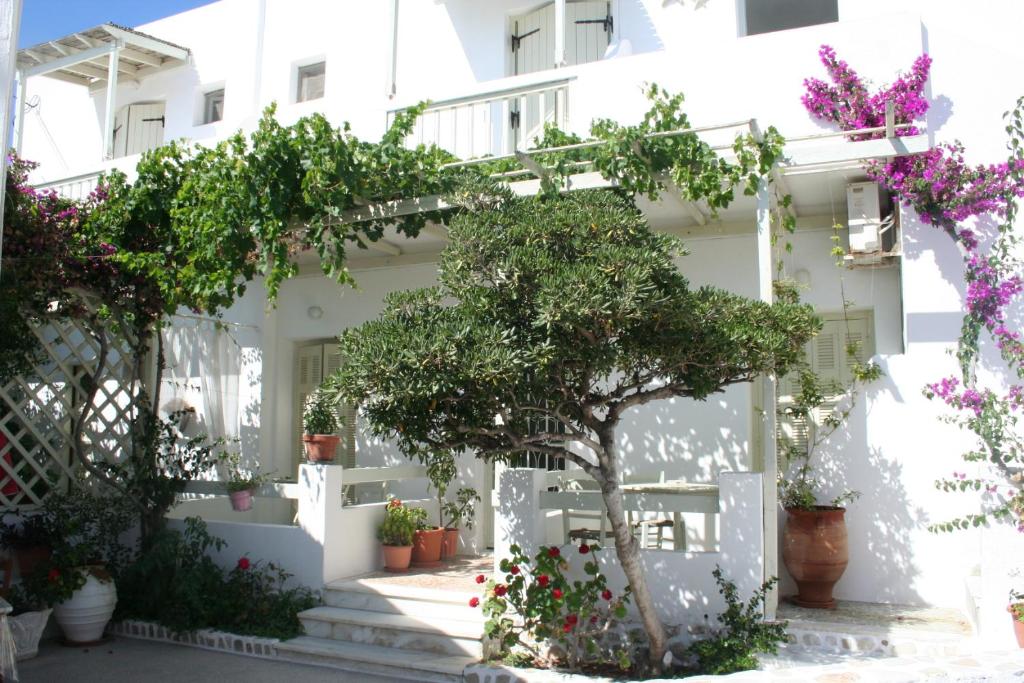 Biały dom z kwiatami na schodach w obiekcie Korali Hotel w mieście Antiparos