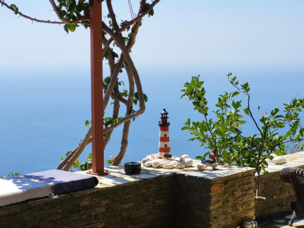 a lighthouse sitting on top of a stone wall at The Stone Lookout Villa in Apróvaton